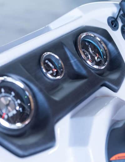 Close-up of boat dashboard showing speedometer and gauges for marine navigation.