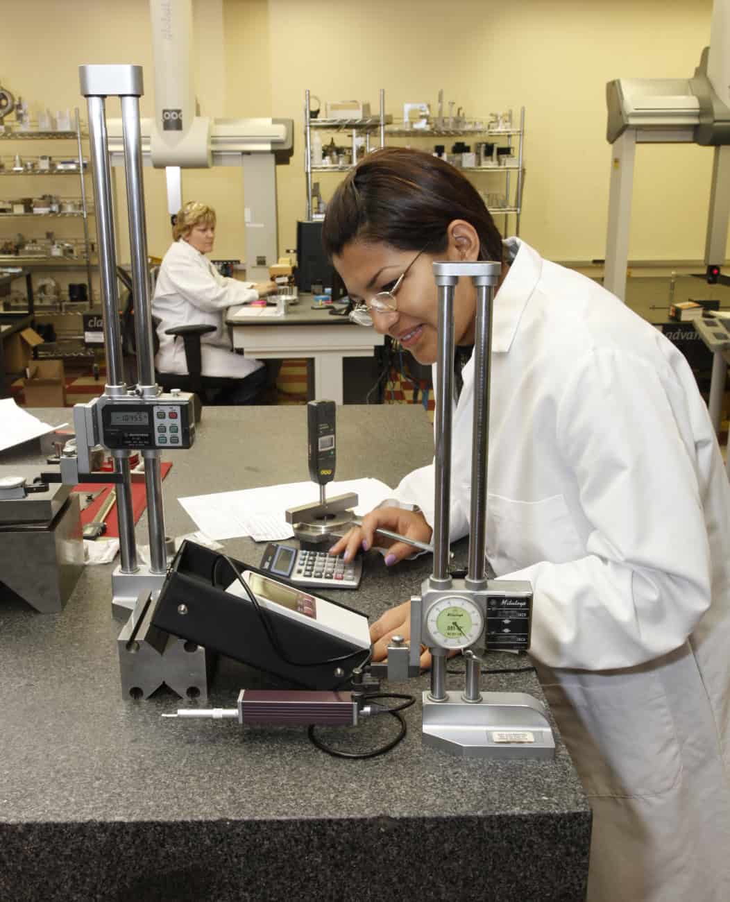 A technician inspects tolerances in a QA lab
